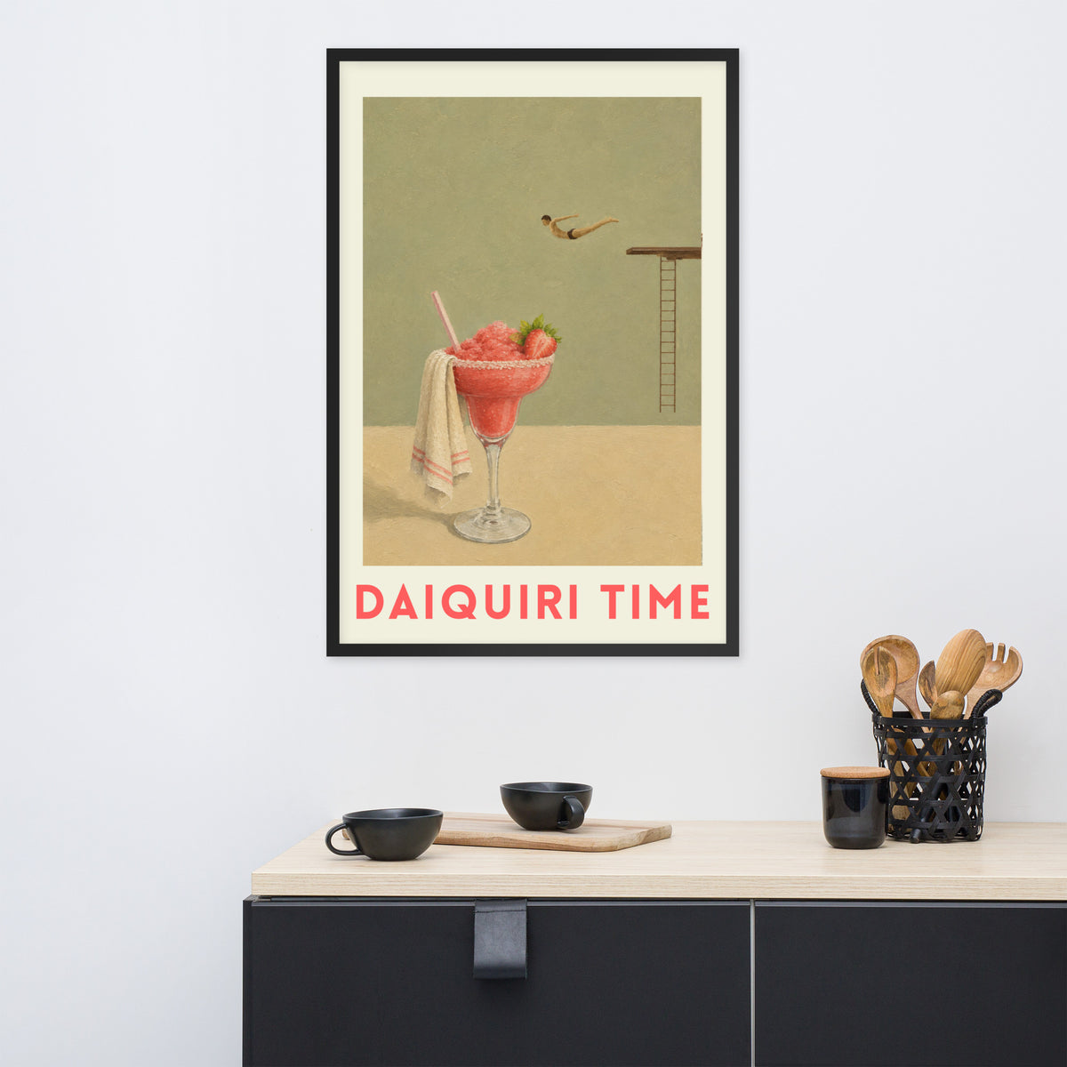 A framed retro-style poster reading 'DAIQUIRI TIME'. The poster shows a pink drink in a glass with a towel and a small diver above a ladder.