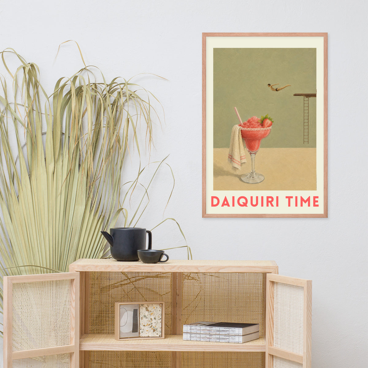 A framed retro-style art print titled 'DAIQUIRI TIME'. The print features a pink daiquiri cocktail glass with a towel and a small diver against a muted green and beige background.