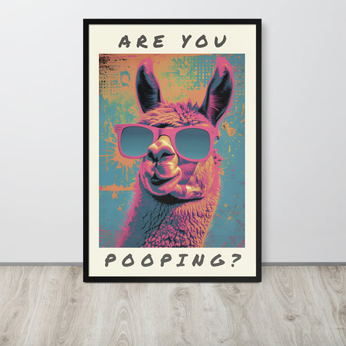 Funny washroom wall art poster leaning against a light wall on a wood floor. The poster shows a colorful alpaca wearing pink sunglasses, with the text 'ARE YOU POOPING?' above and below the artwork.