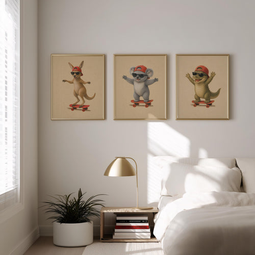 Three framed vertical nursery wall art prints featuring a kangaroo, koala, and alligator wearing red caps and riding skateboards, displayed on a light gray wall above a bed in a modern bedroom setting.