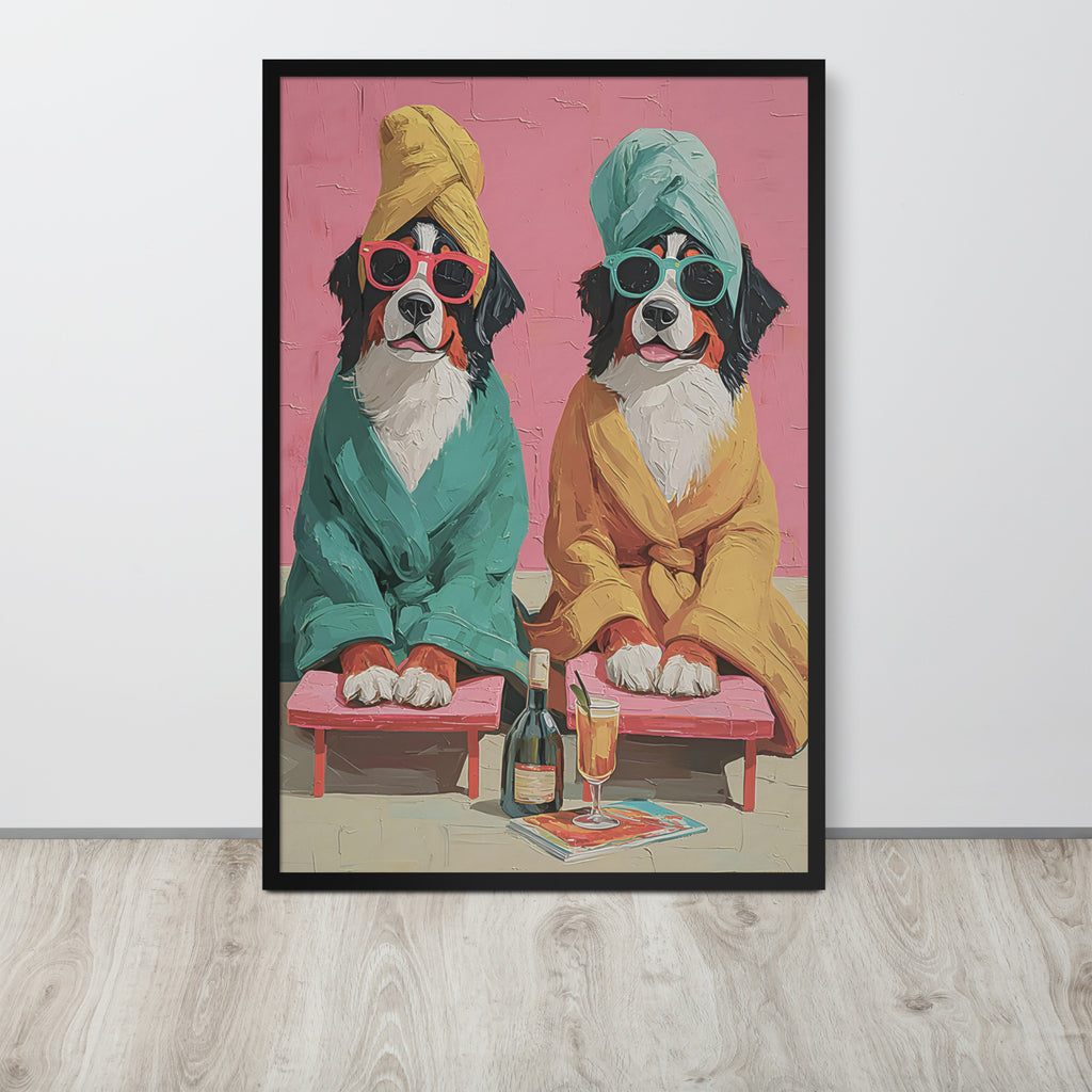 Funny dog bathroom art print depicting two Bernese mountain dogs dressed in bathrobes and towels, sitting on pink chaise lounges with a bottle and glass in front, displayed on a light wood floor against a white wall.