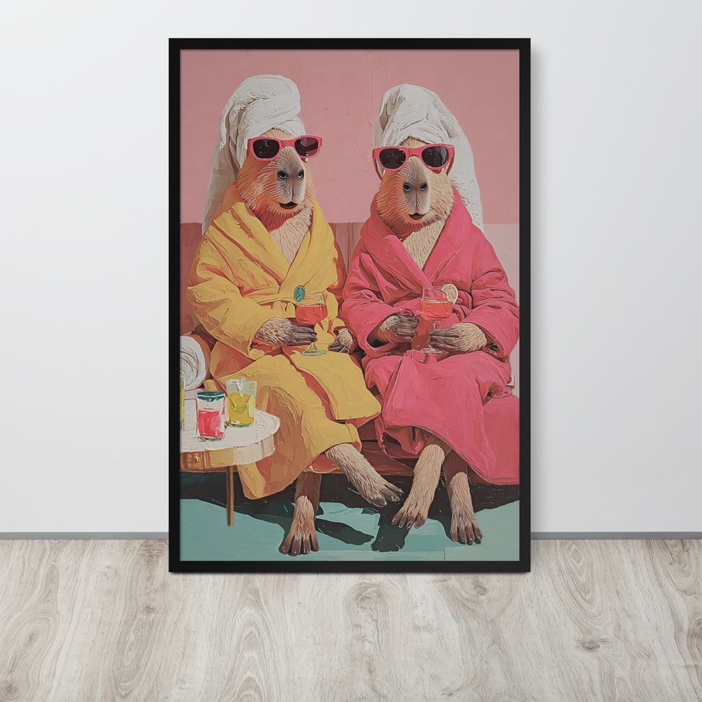 Capybara wall art print featuring a stylized illustration of two anthropomorphic capybaras in pink and yellow robes wearing white towels and sunglasses, sitting on a bench against a pink background. The print is displayed on a light gray wall above a light wood floor.