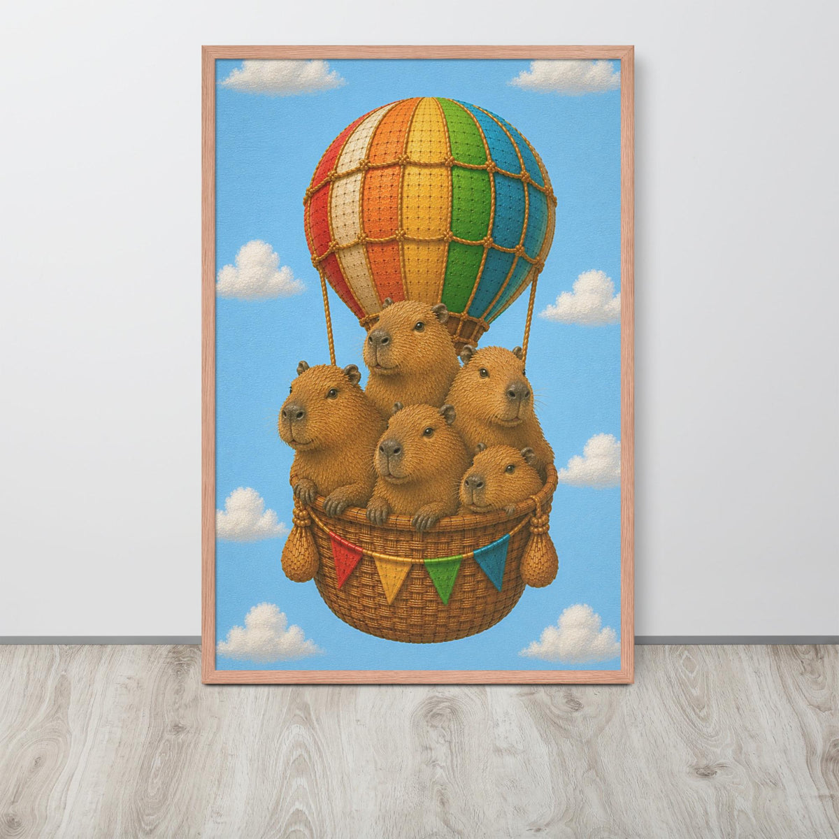 A framed animal nursery wall art print featuring a whimsical illustration of five capybara animals sitting in a wicker basket beneath a large striped hot air balloon, set against a light blue sky with white clouds.