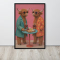 A framed funny farmhouse wall art print featuring two fluffy Highland cows in sunglasses, one in a teal blazer and one in an orange polka-dot jacket, standing behind a small table with wine glasses and cheese. The print is displayed on a light gray wall above a light wood floor.
