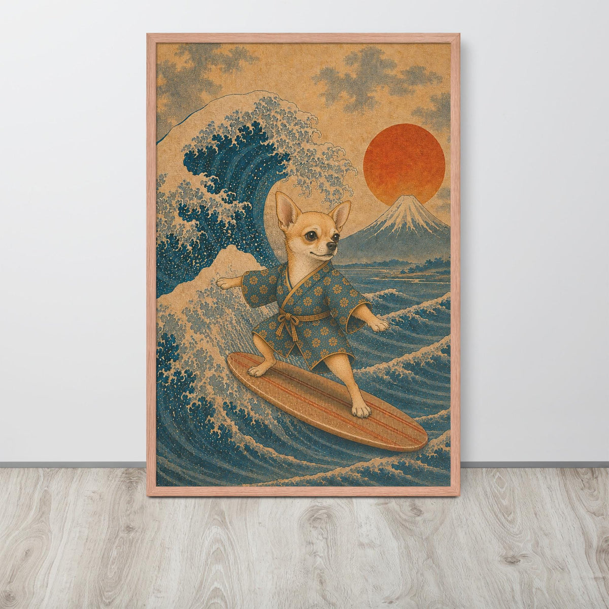 A framed Japanese wall art print featuring a chihuahua dog surfing near Mount Fuji under a red sun, styled leaning against a white wall on a light wood floor.