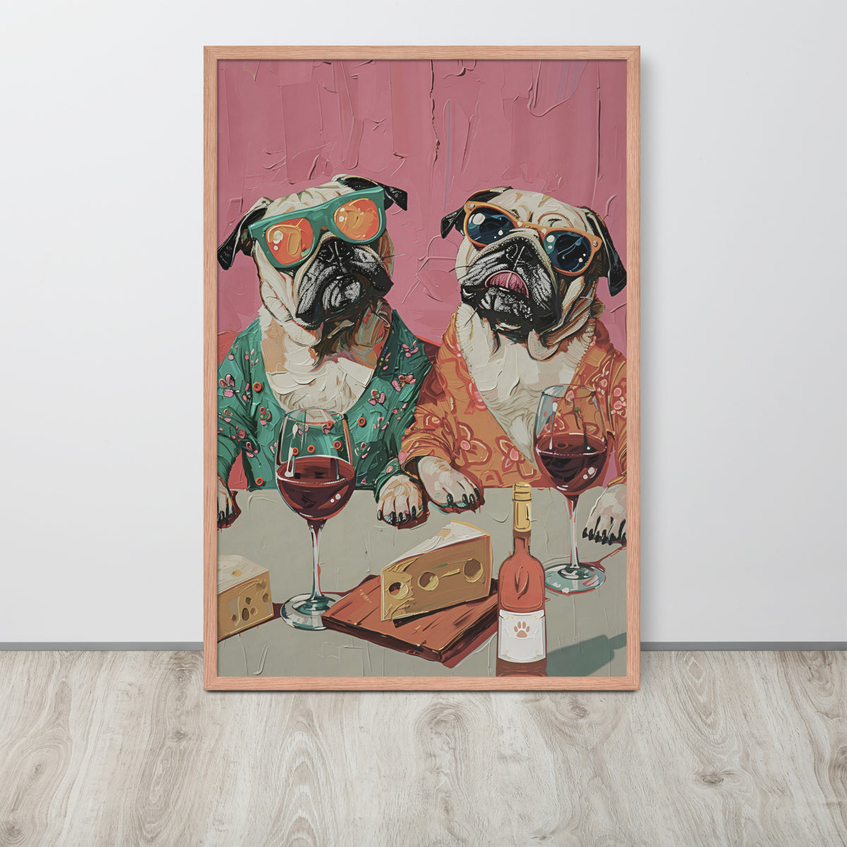 Funny kitchen art print featuring two pug dogs in retro floral shirts wearing sunglasses and sitting at a table with wine glasses, cheese, and a bottle, displayed against a light gray wall on a wood floor.