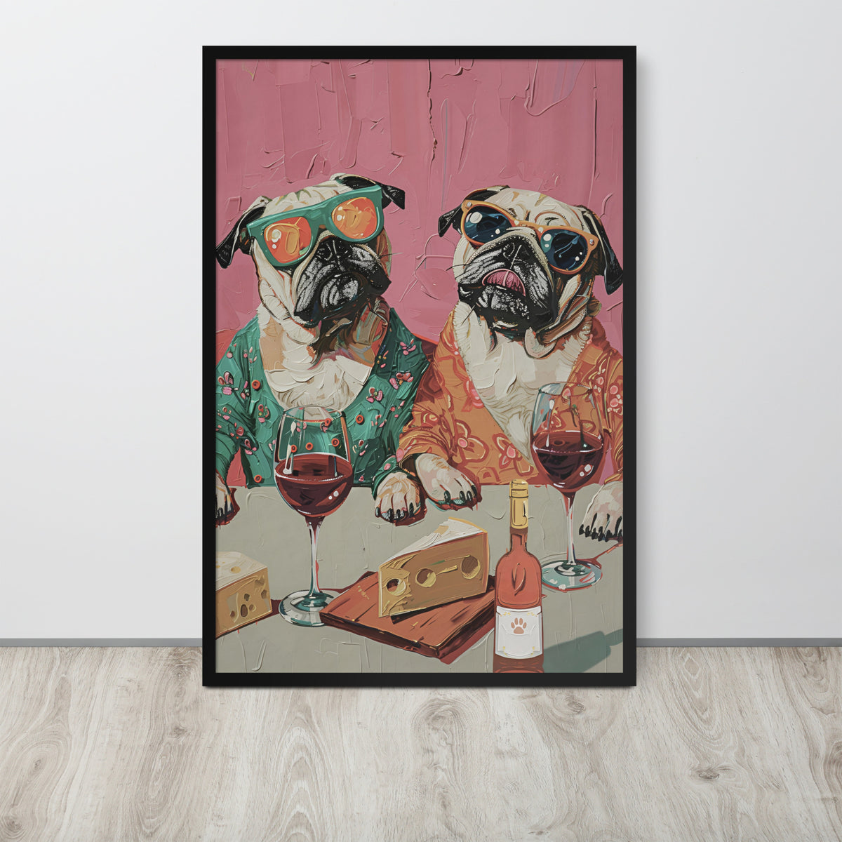Funny pug dog art print featuring two pug dogs in colorful outfits sitting at a table with wine glasses, cheese, and a bottle, displayed against a light wall on a light wood floor.