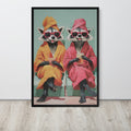 Funny raccoon wall art print featuring two cartoon raccoons wearing pink sunglasses and robes, sitting and holding drinks. The print is displayed on a light gray wall above a light wood floor.