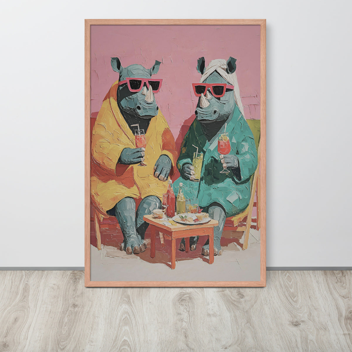 funny rhino bedroom wall art print featuring two rhinos wearing pink sunglasses and colorful robes, sitting at a small table with drinks. The print is displayed against a light gray wall on a light wood floor.
