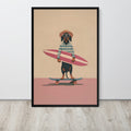Surfing dachshund wall art print featuring a dachshund wearing sunglasses and a hat, holding a pink surfboard while skateboarding on a pink ground against a beige background. The print is displayed on a light gray wall above a light wood floor.