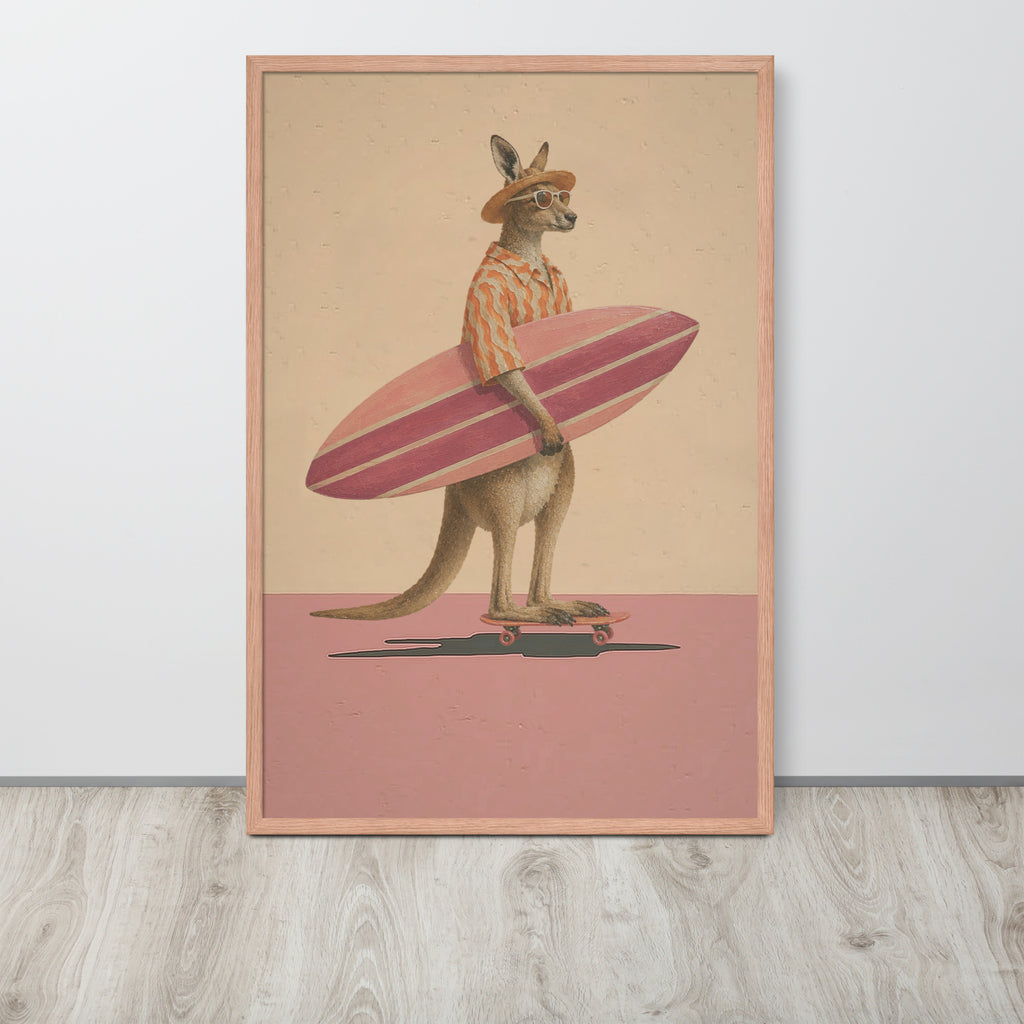 A framed wall art print featuring an anthropomorphic kangaroo wearing a striped shirt and hat, holding a pink surfboard while standing on a skateboard. The print is displayed leaning against a white wall on a light wood floor.