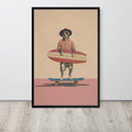 Pitbull dog wall art print featuring a dog dressed as a surfer holding a red and white surfboard while standing on a skateboard, displayed against a light gray wall on a light wood floor.