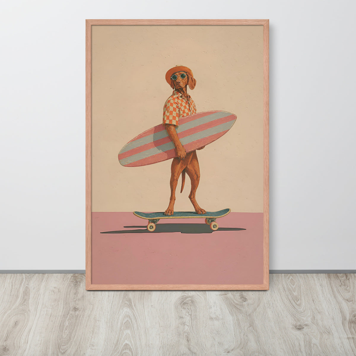 Vizsla dog wall art print featuring a stylized brown vizsla dog dressed as a surfer holding a pink and white striped surfboard, standing on a skateboard against a beige and dusty pink background. The print is housed in a light wood frame and is displayed leaning against a white wall on a light gray wood floor.
