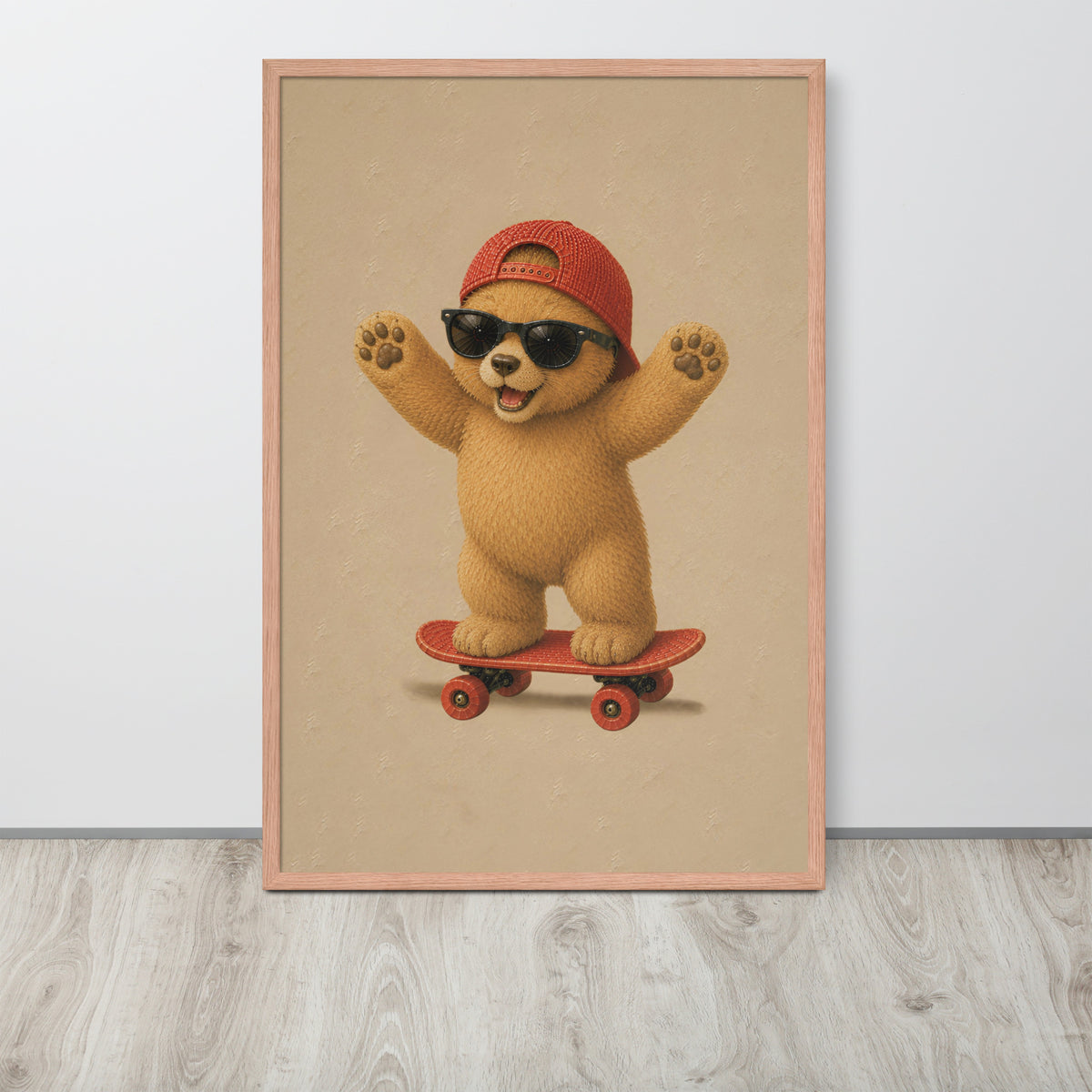 A framed teddy nursery wall art print featuring a cute cartoon bear wearing a red cap and black sunglasses while riding a red skateboard, displayed against a light gray wall on a light wood floor.