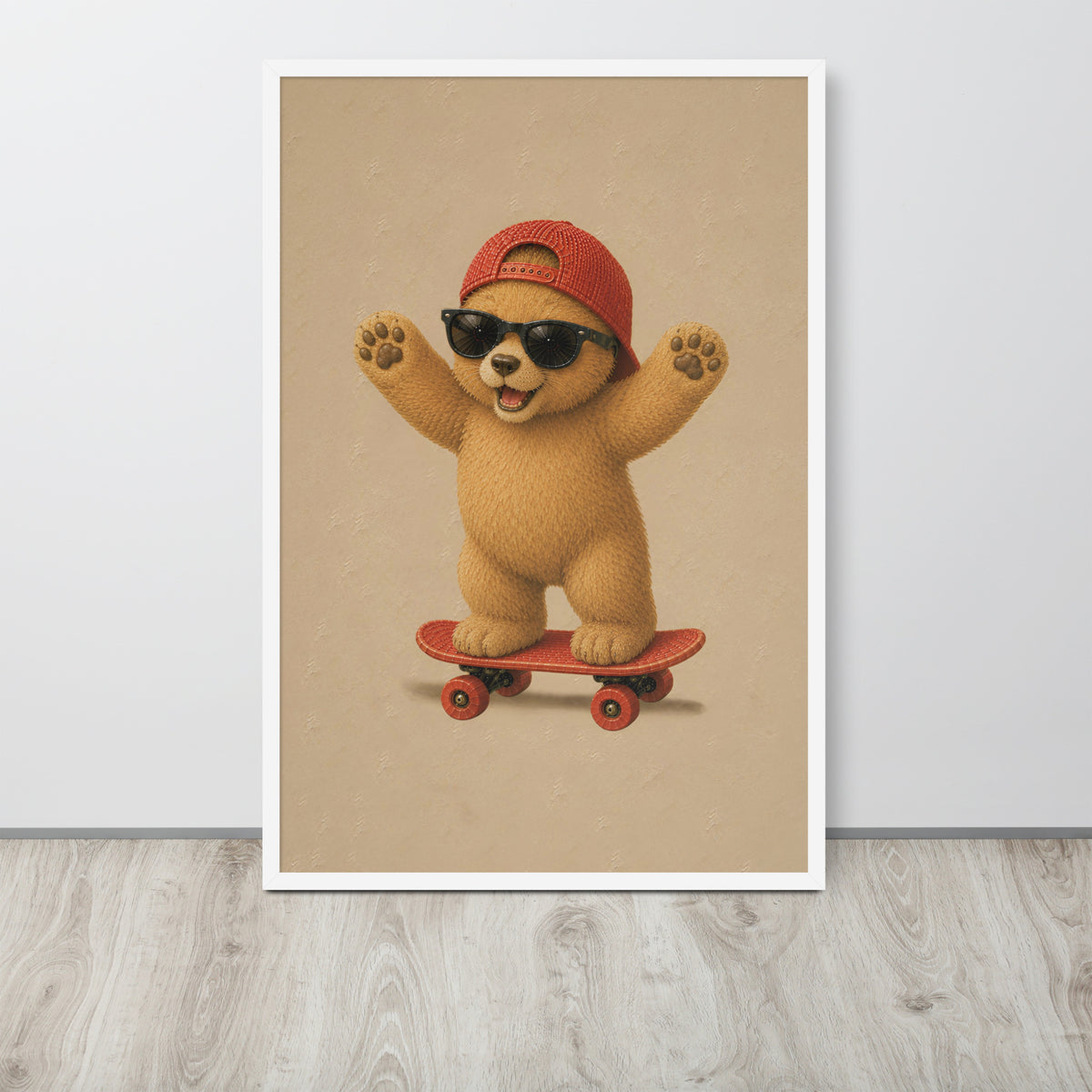 A vertical framed teddy bear nursery decor, wall art print featuring a cute cartoon bear wearing a red cap, black sunglasses, and riding a red skateboard, displayed against a light gray wall on a light wood floor.